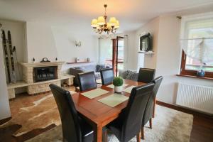 - une salle à manger avec une table et des chaises en bois dans l'établissement Apartament BazaTatry Wielka Krokiew, à Zakopane