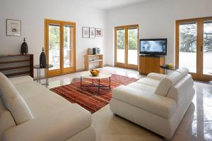 a living room with two white couches and a tv at Private luxury Villa AZZURRO on Solta for up to 10 persons, free parking, very close to beach! FREE Kajak & Mountainbikes, GREAT living area & privacy! in Rogač