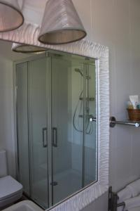 uma cabina de duche em vidro numa casa de banho com luz em Posada el Campo em Secadura