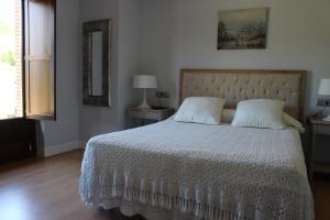 1 dormitorio con 1 cama con edredón blanco en Posada el Campo en Secadura