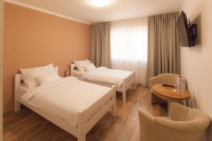 a hotel room with two beds and a chair at Golf Čertovo břemeno in Jistebnice