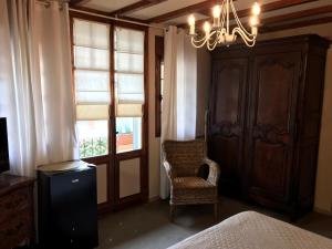 a bedroom with a bed and a chair and a chandelier at La Marjolaine in Juan-les-Pins