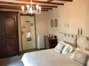a bedroom with a bed with white pillows and a chandelier at La Marjolaine in Juan-les-Pins