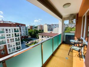 a balcony with chairs and a view of a city at Happy Town Apartments in Veliko Tŭrnovo