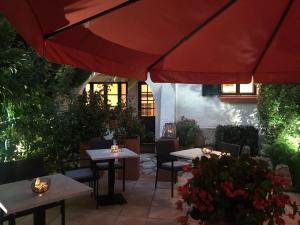 a restaurant with tables and red umbrellas at La Marjolaine in Juan-les-Pins