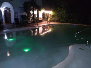 una piscina por la noche con luces verdes en El Pueblito Iguazú en Puerto Iguazú