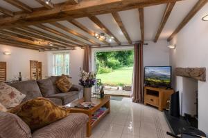 a living room with a couch and a tv at Finest Retreats - The Cottage - Luxury 1 Bed Cottage in Rhydymwyn