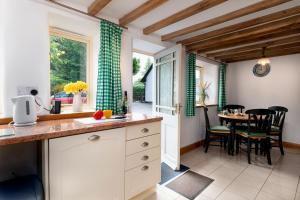 a kitchen and dining room with a table and chairs at Finest Retreats - The Cottage - Luxury 1 Bed Cottage in Rhydymwyn