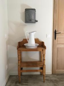 een witte urn op een tafel naast een deur bij gite la magnanerie in Réauville