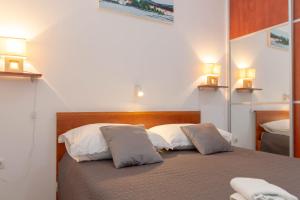 a bedroom with a bed with two pillows on it at Apartman Tradicija in Kaštela