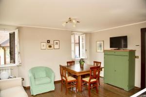uma sala de jantar com uma mesa e um armário verde em Contempora Apartments - Ca' Brenta Patriot em San Fedele Intelvi