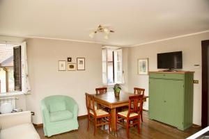 a dining room with a table and a green cabinet at Contempora Apartments - Ca' Brenta Patriot in San Fedele Intelvi