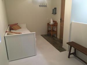 a small white bedroom with a bed and a table at gite la magnanerie in Réauville