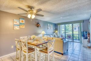 a dining room and living room with a table and chairs at Shorewalk Full Condo Lake view Near to Beach IMG in Bradenton