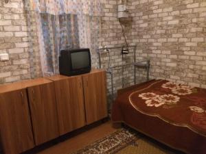 sypialnia z łóżkiem i telewizorem na szafce w obiekcie Сдам комнату в гостевом домике w Odessie