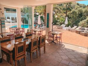 un patio con mesas y sillas y una piscina en Jardines De La Reina Boutique Bed & Breakfast en Marbella