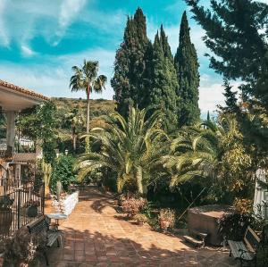a garden area with trees and shrubbery at Jardines De La Reina Boutique Bed & Breakfast in Marbella