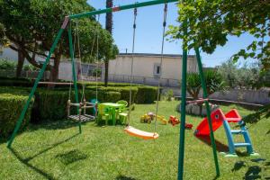 a yard with a playground with swings at Apartman Tradicija in Kaštela