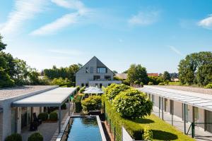 ein Haus mit einem Pool neben einem Gebäude in der Unterkunft Abalona Hotel & Apartments in Dendermonde