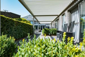 un bâtiment avec des bancs et des buissons à côté d'un bâtiment dans l'établissement Abalona Hotel & Apartments, à Termonde 99 autres photos