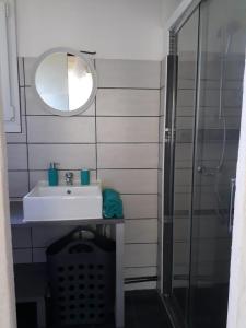 La salle de bains est pourvue d'un lavabo et d'une douche. dans l'établissement Maisonnette proche de la plage, à Tarnos