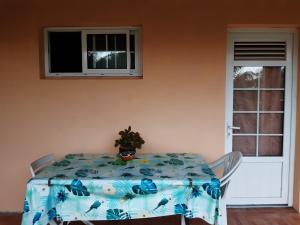 une table avec un chiffon bleu et une plante sur elle dans l'établissement ecrin de verdure, à Fort-de-France