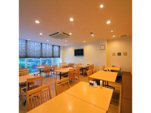 una sala da pranzo con tavoli e sedie in legno di HOTEL SUN OCEAN - Vacation STAY 84242 a Anan