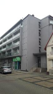 a white building with a car parked in front of it at Dom Rybaka apartament 4 in Ustka