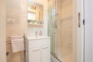 La salle de bains blanche est pourvue d'une douche et d'un lavabo. dans l'établissement Apartment Stella old town Trogir, with balcony, à Trogir