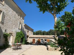 an external view of a building with a table and chairs at Le Mas du Pigeonnier in Réauville