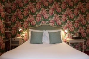 a bedroom with a bed with pink flowers on the wall at Les Prés D'ondine in Sélestat