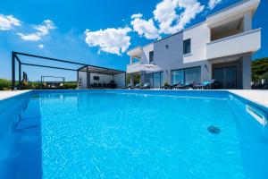 a swimming pool in front of a villa at Villa Sky - Heating Pool in Kastel Novi