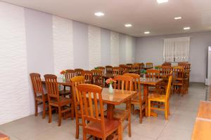 een eetkamer met houten tafels en stoelen bij Pousada Tesouro de Minas - Centro Histórico in Tiradentes
