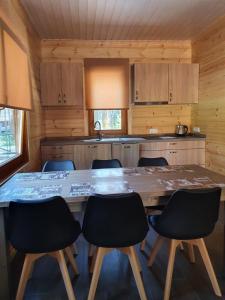 SPLIFE plus في Kuru: مطبخ مع طاولة وكراسي خشبية كبيرة