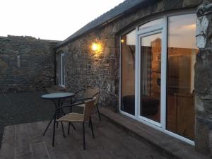 a patio with a table and chairs next to a building at The Stables in Castle Douglas