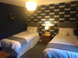 a hotel room with two beds and a wall with a wallpaper at The Stables in Castle Douglas +6 photos