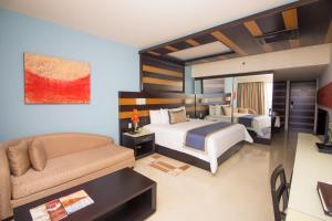 a hotel room with two beds and a couch at Secrets Huatulco Resort & Spa in Santa Cruz Huatulco