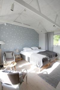 1 dormitorio con 1 cama grande y 1 silla en Tuna Orangeri, en Nyköping