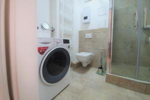 een wasmachine in een badkamer met een toilet bij PB Ferienwohnungen - FeWo 2 - Stilvoll eingerichtetes Apartment im Herzen Senftenbergs in Senftenberg