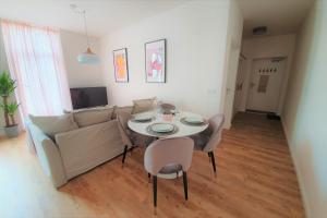 a living room with a couch and a table and chairs at PB Ferienwohnungen - FeWo 2 - Stilvoll eingerichtetes Apartment im Herzen Senftenbergs in Senftenberg