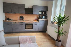 een keuken met roestvrijstalen apparatuur en een witte bank bij PB Ferienwohnungen - FeWo 2 - Stilvoll eingerichtetes Apartment im Herzen Senftenbergs in Senftenberg