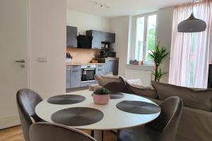 a living room with a white table and chairs at PB Ferienwohnungen - FeWo 2 - Stilvoll eingerichtetes Apartment im Herzen Senftenbergs in Senftenberg