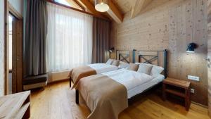 two beds in a room with wooden walls at Apartmány iziJasná & Chalets in Demanovska Dolina +80 photos