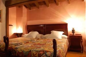a bedroom with a bed with a colorful comforter at La Casona de Villanueva de Colombres in Villanueva