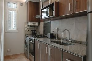 a kitchen with a sink and a stove at DOMUS APART - Cochera Incluida in Río Cuarto
