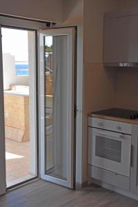 a kitchen with a sliding glass door leading to a patio at Seaside Studio Meltemi in Rafina