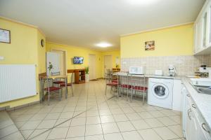 cocina con paredes amarillas y lavadora en Betty Apartman Hajdúszoboszló, en Hajdúszoboszló