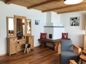 ein Wohnzimmer mit einem Schreibtisch und einem TV in der Unterkunft Ferienwohnungen Meusburger in Tannheim