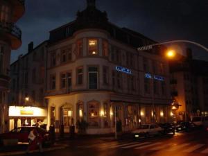 - un grand bâtiment blanc dans une rue de la ville la nuit dans l'établissement Hotel-Restaurant Windsor, à Mondorf-les-Bains