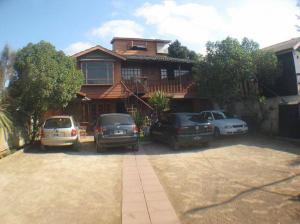 una casa con coches aparcados delante de ella en Cabañas Orion, en Concón